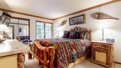 a bedroom with a wooden bed and a desk at Walk to Mammoth Ski Lifts at Canyon Lodge Condo in Mammoth Lakes
