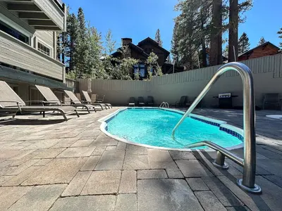a swimming pool with a slide in a yard at Walk to Mammoth Ski Lifts at Canyon Lodge Condo in Mammoth Lakes
