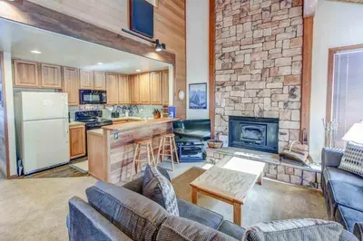 a living room with a couch and a kitchen at Canyon Ski & Racquet #1 Near Hike & Bike Trails in Mammoth Lakes