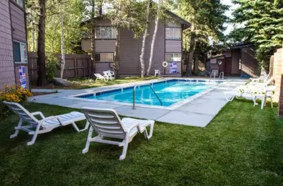a swimming pool with lounge chairs in a yard at Sierra Manors #098 Nearby Hike & Bike Trails in Mammoth Lakes