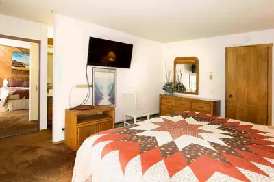 a bedroom with a bed and a dresser and a television at Snowcreek #059 Near Shuttle & Activities in Mammoth Lakes