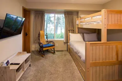 a bedroom with a bunk bed and a desk and a television at Snowcreek #566 Near Golf & Shuttle in Mammoth Lakes