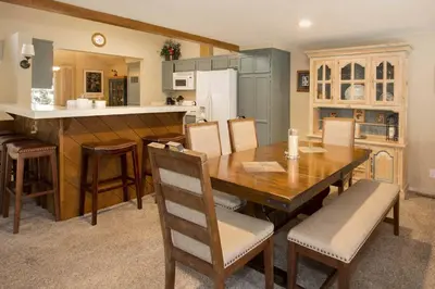 a kitchen and dining room with a wooden table and chairs at Snowcreek #566 Near Golf & Shuttle in Mammoth Lakes