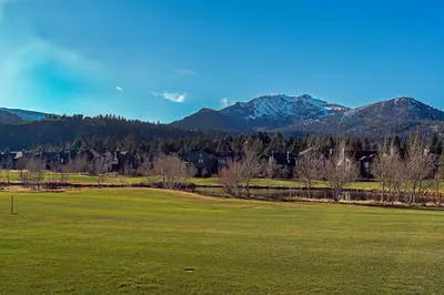 a green field with mountains in the background at Snowcreek #630 Near Lakes & Golf in Mammoth Lakes