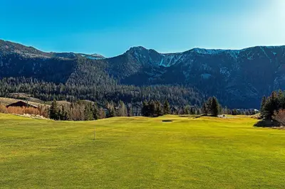 a green golf course with mountains in the background at Snowcreek #630 Near Lakes & Golf in Mammoth Lakes