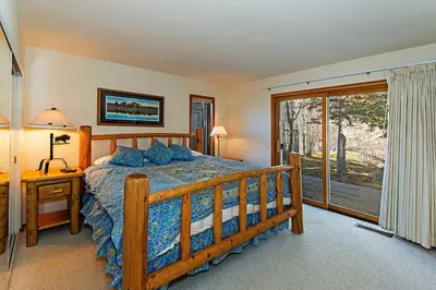 a bedroom with a wooden bed and a window at SnowCreek #936 Shared Pool & Hot Tub in Mammoth Lakes