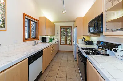 a kitchen with white counters and a stove top oven at SnowCreek #936 Shared Pool & Hot Tub in Mammoth Lakes