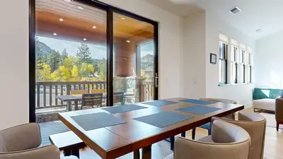 a dining room with a table and chairs and a balcony at Cozy Cabin for 8 Close to Eagle Lodge in Mammoth Lakes