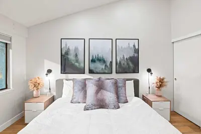 a bedroom with a white bed with four pictures on the wall at St Anton Getaway Shared BBQ Pool & Hot Tub in Mammoth Lakes