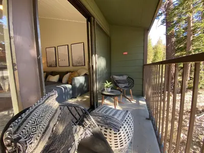 a porch with a bench and a bed on a balcony at St Anton Getaway Shared BBQ Pool & Hot Tub in Mammoth Lakes