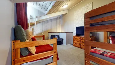 a bedroom with two bunk beds and a television at Chamonix #70 Near Yearly Outdoor Activities in Mammoth Lakes