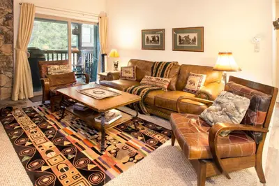 a living room with a couch and a table at Chamonix Year-Round Fun with Shared Pool in Mammoth Lakes