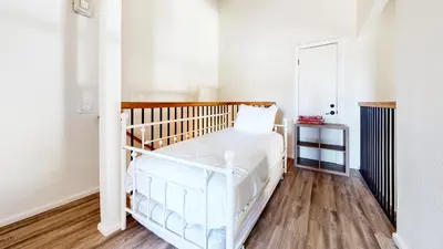 a white crib in a room with wooden floors at Crestview #2 Close to The Village Near Year-Round Outdoor Activities in Mammoth Lakes