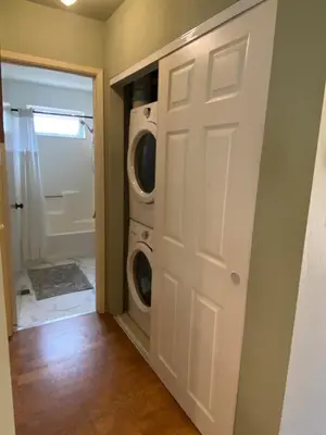 a laundry room with a washer and dryer next to a door at Bearfoot Cabin 15 Min to Yosemite Gate! in Oakhurst