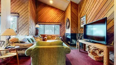 a living room with a couch and a flat screen tv at Chic 1 BDR Loft with Hot Tub Near Canyon Lodge in Mammoth Lakes