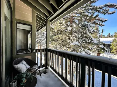 a balcony with a chair and a snow covered tree at Chic 1 BDR Loft with Hot Tub Near Canyon Lodge in Mammoth Lakes