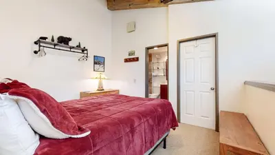 a bedroom with a bed with a red blanket at Escape to The Summit Pool & HT Next Door in Mammoth Lakes