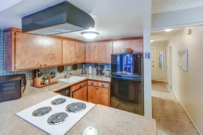 a kitchen with wooden cabinets and a stove top oven at Fireside Pool Access Hot Tub & More in Mammoth Lakes