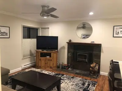 a living room with a flat screen tv and a fireplace at Fireside at The Village Near Hike Bike in Mammoth Lakes