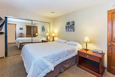 a bedroom with two beds and a mirror at Grayeagle 08 Cozy Ambiance with Hot Tub in Mammoth Lakes
