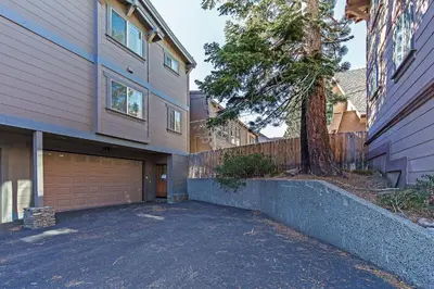 a house with a garage next to a tree at Grayeagle 08 Cozy Ambiance with Hot Tub in Mammoth Lakes
