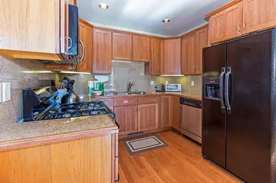 a kitchen with wooden cabinets and a black refrigerator at Grayeagle 08 Cozy Ambiance with Hot Tub in Mammoth Lakes