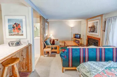 a bedroom with a bed and a living room at Studio with Amenities Walk to Village in Mammoth Lakes