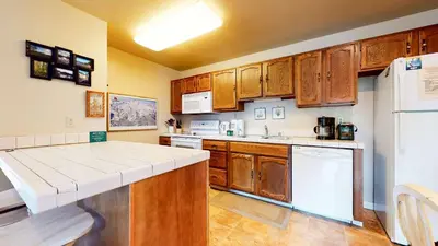 a kitchen with wooden cabinets and a white refrigerator at Hidden Valley Homestead Near Hike Bike & More in Mammoth Lakes