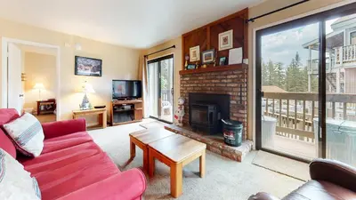 a living room with a red couch and a fireplace at Hidden Valley Homestead Near Hike Bike & More in Mammoth Lakes