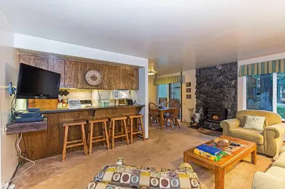 a living room with a couch and a kitchen with a tv at Horizons Year-Round Fun with Rec Room in Mammoth Lakes
