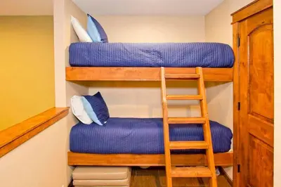 a room with two bunk beds and a ladder at Horizons Condo with Communal Clubhouse in Mammoth Lakes