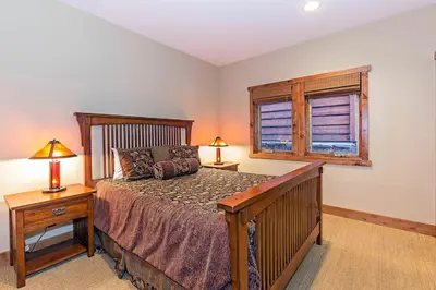 a bedroom with a wooden bed and a window at Stonegate #02 Luxe Condo with Foosball Table in Mammoth Lakes