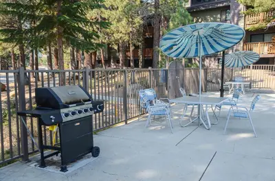 a grill and a table with chairs and an umbrella at Summit #20 Near DT Hike Bike & Ski in Mammoth Lakes