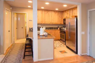 a kitchen with wooden cabinets and a stainless steel refrigerator at Summit #20 Near DT Hike Bike & Ski in Mammoth Lakes