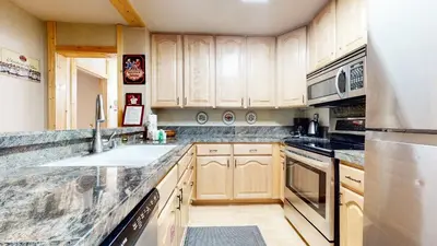 a kitchen with wooden cabinets and stainless steel appliances at Summit Cozy Condo Getaway in Mammoth Lakes