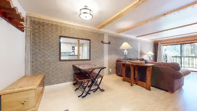 a living room with a bed and a desk and a mirror at Summit Cozy Condo Getaway in Mammoth Lakes