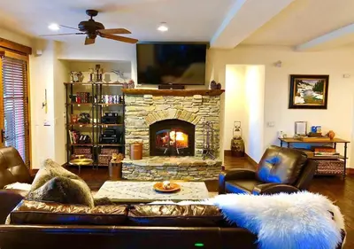 a living room with a couch and a stone fireplace at The Lodges by 8th Hole Year-Round Fun in Mammoth Lakes