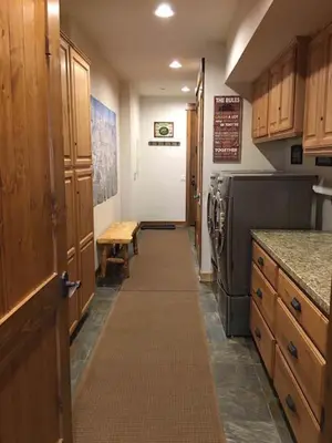 a kitchen with a hallway with a refrigerator and a table at The Lodges by 8th Hole Year-Round Fun in Mammoth Lakes