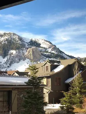 a house with snow on the roof and a mountain at The Lodges by 8th Hole Year-Round Fun in Mammoth Lakes