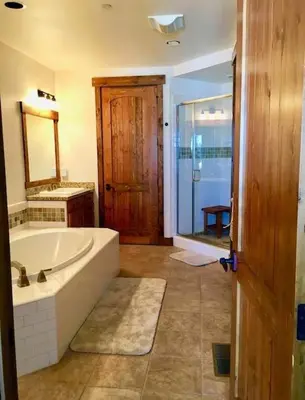 a large bathroom with a tub and a mirror at The Lodges by 8th Hole Year-Round Fun in Mammoth Lakes
