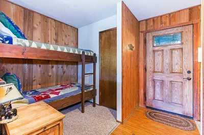 a bedroom with two bunk beds and a door at Viewpoint #131 Walk to Eats & Entertainment in Mammoth Lakes