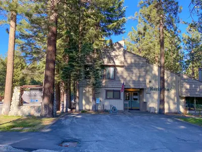 a white house with trees in front of a driveway at Horizons 4 - Year-Round Outdoor Activities in Mammoth Lakes