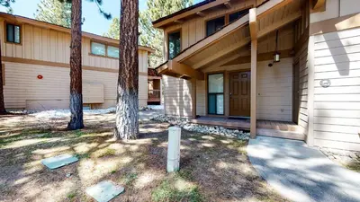 a house with a porch and a tree at Villa De Los Pinos Year-Round Activities Nearby Shopping & Restaurants in Mammoth Lakes