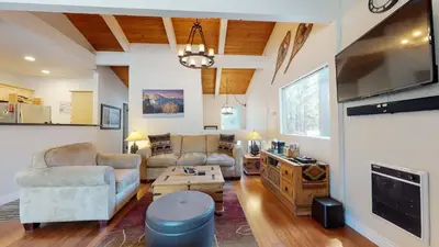 a living room with two couches and a flat screen tv at Villa De Los Pinos Year-Round Activities Nearby Shopping & Restaurants in Mammoth Lakes