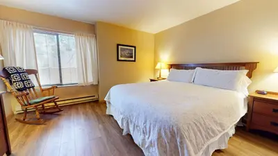 a bedroom with a bed and a chair and a window at Horizons Bliss - Near Year-Round Activities in Mammoth Lakes