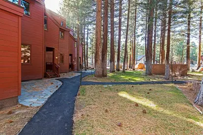 a driveway leading to a red house with trees at Winterset #02 Shared Hot Tub & Pool in Mammoth Lakes