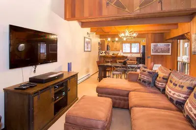 a living room with a couch and a flat screen tv at Winterset #28 Shared Hot Tub & Sauna in Mammoth Lakes