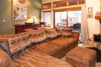 a living room with a large brown couch and chairs at Winterset #28 Shared Hot Tub & Sauna in Mammoth Lakes