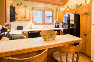 a kitchen with wooden cabinets and a counter top at Winterset #28 Shared Hot Tub & Sauna in Mammoth Lakes