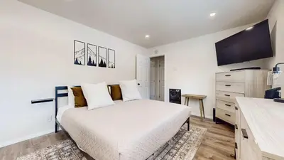 a white bedroom with a bed and a tv at Jackson's Alpine Retreat - For 4 in Mammoth Lakes